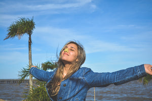 Girl basking in the sun with Noz’s vegan, cruelty-free, reef safe, eco-friendly, green sunscreen on her nose. 